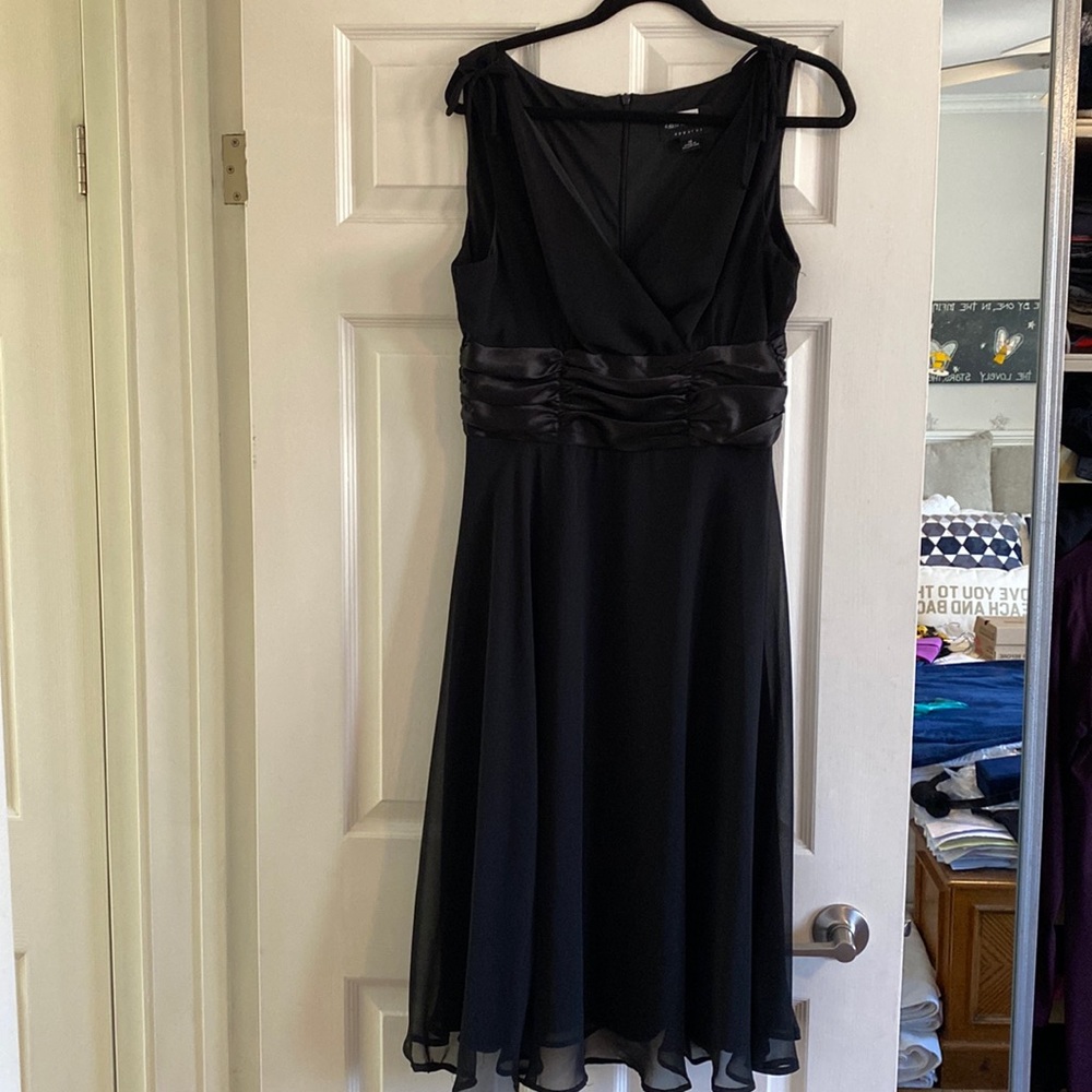 Elegant black dress with satin midsection and a beautiful hemline. Size 12.